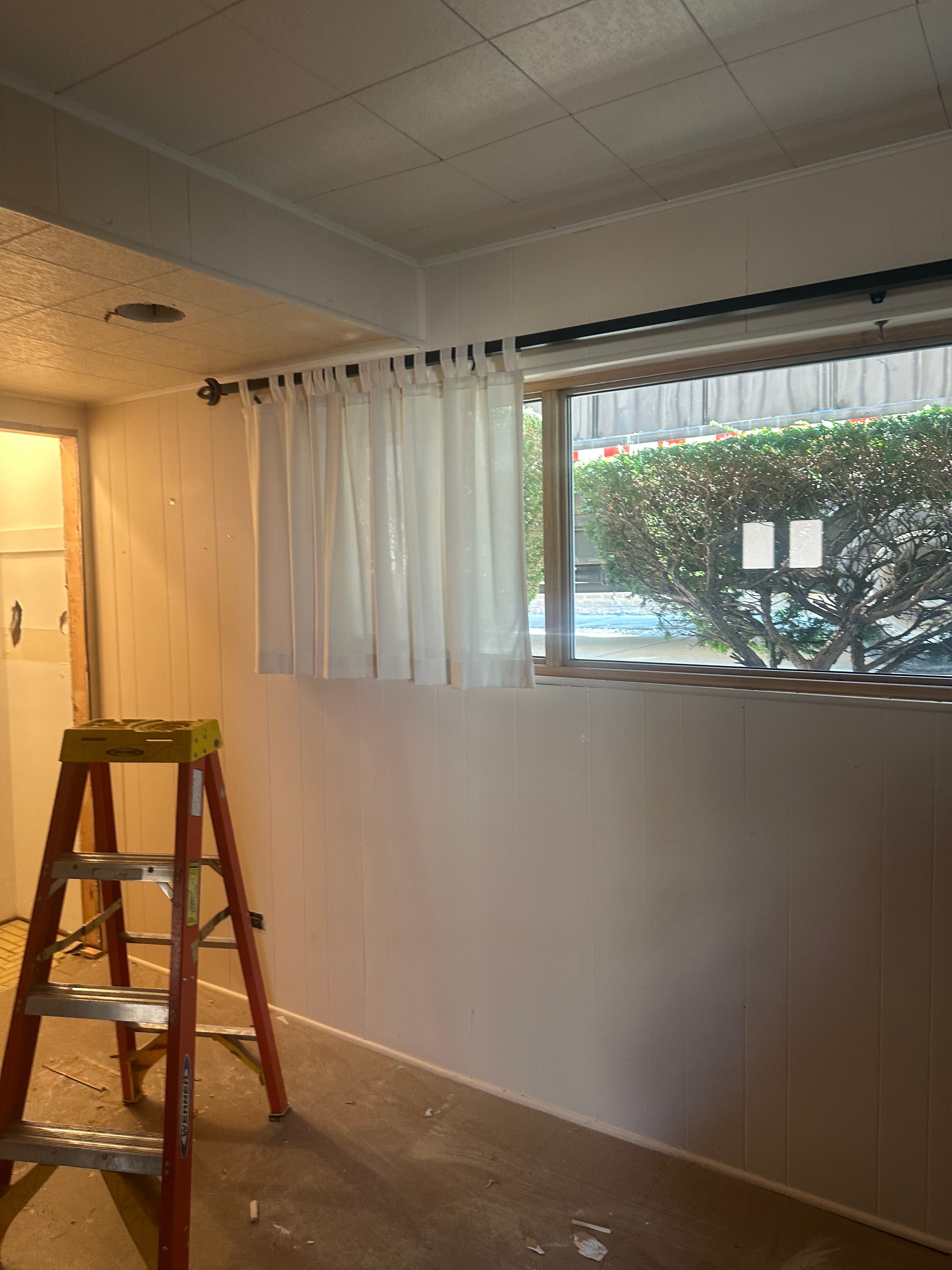 Interior room before light demolition — ladder and materials on site
