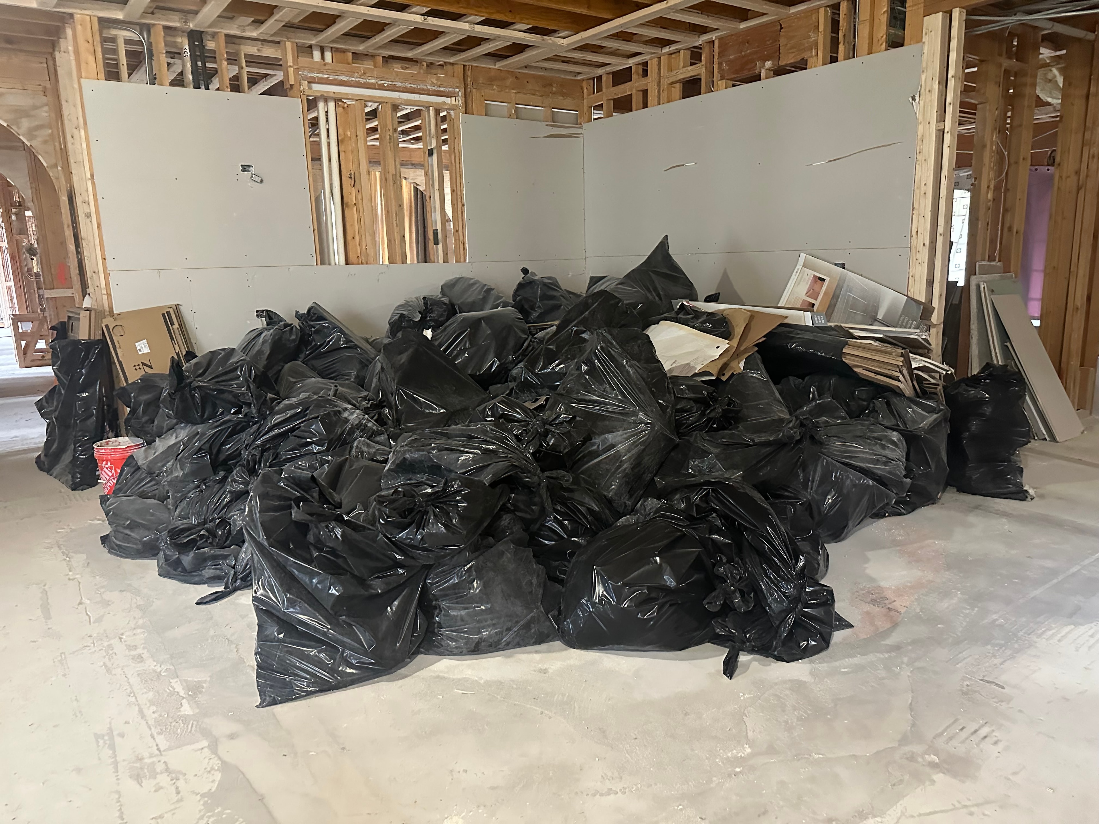 Construction site before debris removal — exposed framing and demolition waste